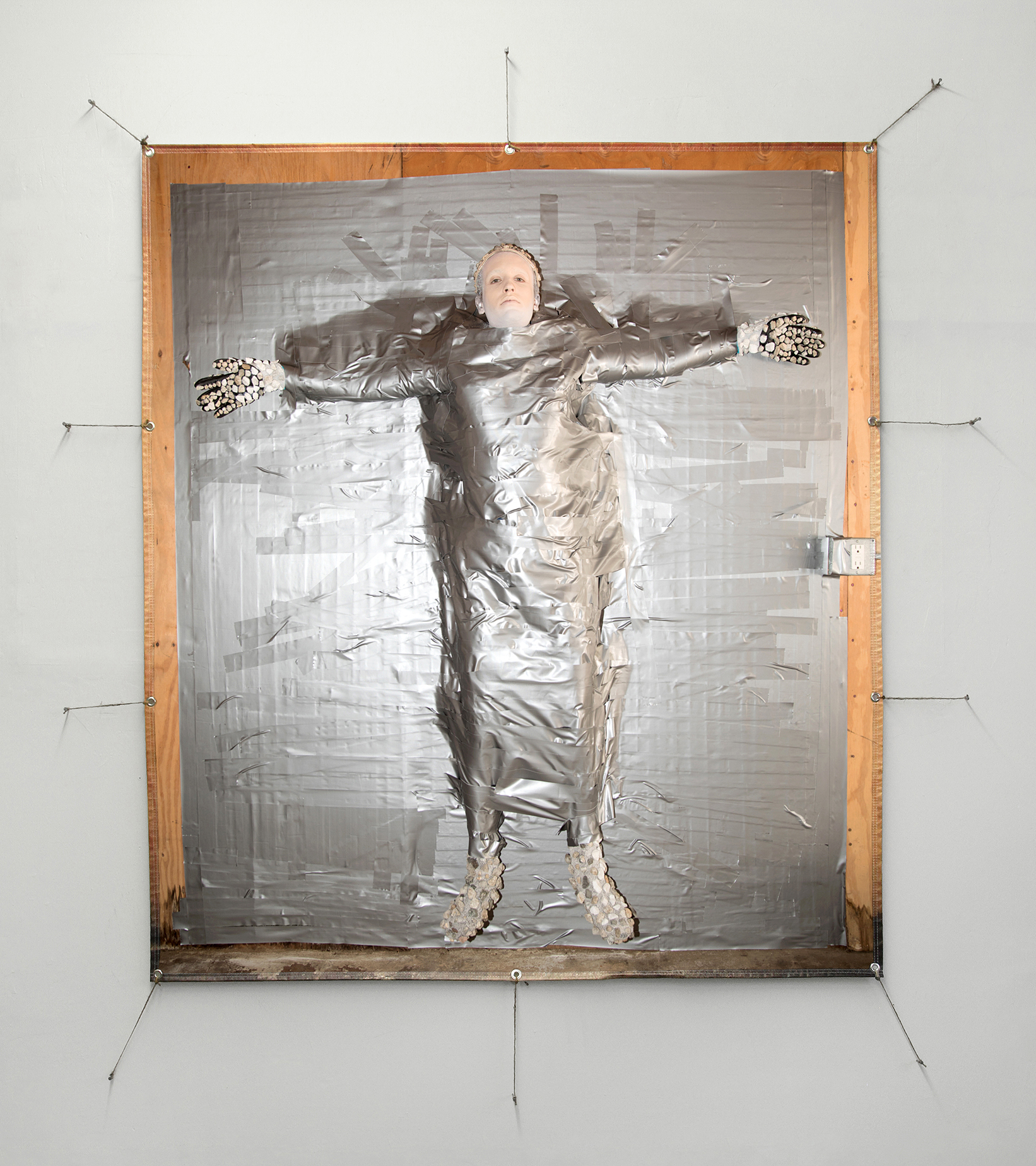 Vinyl photographic print of Jesse duct taped to a wooden wall.